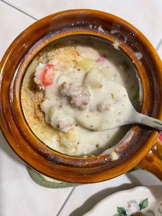 a close up of a bowl of food on a table with a spoon in it