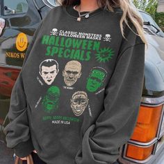 a woman standing in front of a car wearing a sweatshirt with halloween specials on it