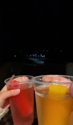 two people are holding glasses with drinks in them