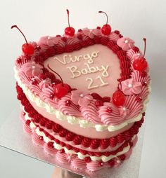 a heart shaped cake with the words virgo baby 21st on it and cherries