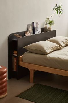 a bed with two pillows on it and a book shelf in the corner next to it