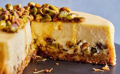 a piece of cheesecake with pistachios on top and one slice missing