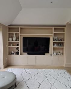 a living room with an entertainment center and white rug