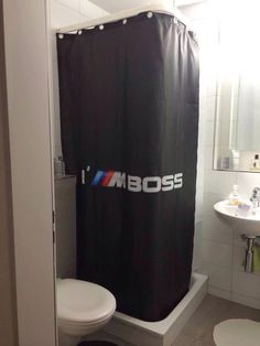 a black shower curtain with the word i amboss on it in a bathroom