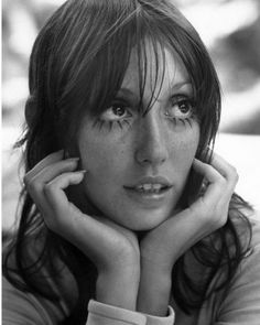 a black and white photo of a woman with freckles on her eyes looking at the camera