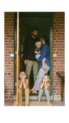 a group of people that are standing in the door way with their hands on each other's heads