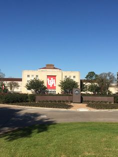 a large building with a red and white sign on it's front entrance is seen from across the street