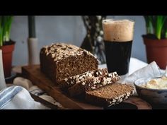 a loaf of bread sitting on top of a cutting board next to a bowl of food