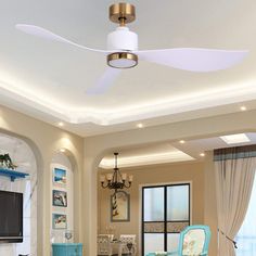 a living room with blue chairs and a ceiling fan in the middle of the room