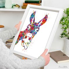 a person holding up a colorful animal art print