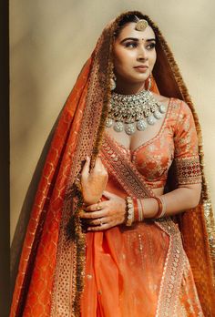 a woman in an orange and gold bridal outfit