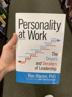 a person holding up a book that says personality at work and the drivers of leadership