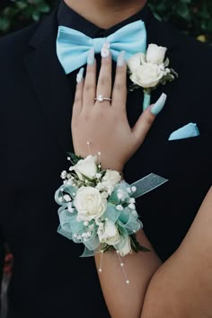 a close up of a person wearing a suit and tie with flowers on his lapel