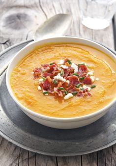 a bowl of soup with bacon and cheese on top