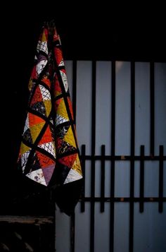 a quilt hanging on a fence in the dark