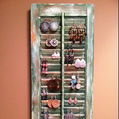 an old window with earrings hanging on it