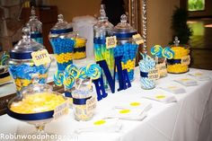 a table topped with candy and candies covered in blue, yellow and white decorations