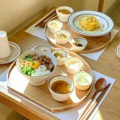 a wooden table topped with plates and bowls filled with different types of food on top of it