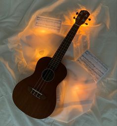 a wooden ukulele sitting on top of a white sheet