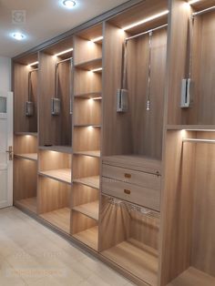 an empty walk - in closet with wooden shelves and lights on the ceiling, along with white tile flooring