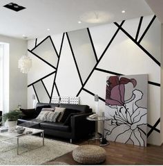 a modern living room with black and white lines on the wall, leather couches and coffee table