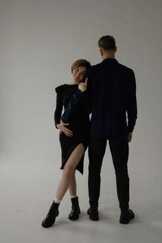 a man and woman standing next to each other in front of a white background,