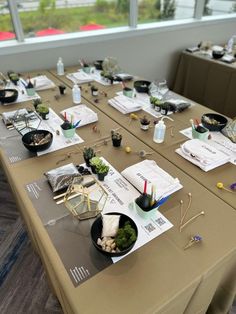 a long table is set up with place settings for an event or conference in front of large windows