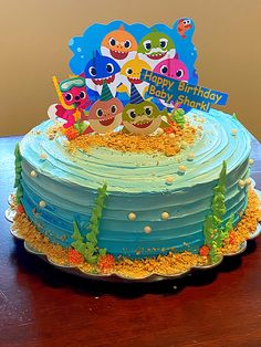 a birthday cake that has been decorated with cartoon characters and sand on the bottom layer