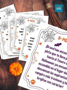 four halloween cards with spanish words on them and a pumpkin next to one that has been placed in front of it