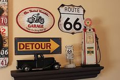 the wall has various signs and gas pumps on it, along with a clock that says route 66