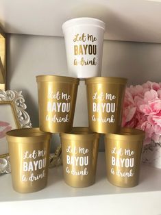 gold cups with different sayings on them