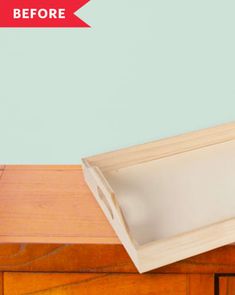 an empty tray sitting on top of a wooden dresser next to a blue wall with the words, before and after