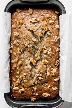 a loaf of bread with walnuts on top in a baking pan, ready to be baked