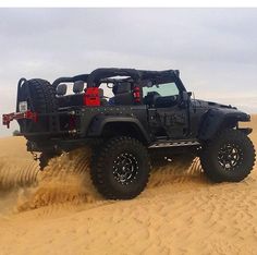 a jeep driving through the sand in the desert