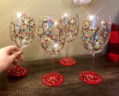 hand painted wine glasses with colorful sprinkles on the bottom and red bases