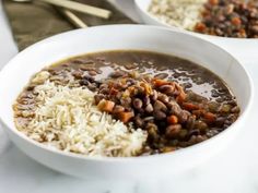 two white bowls filled with beans and rice