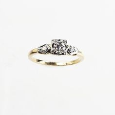 a three stone diamond ring on a white background