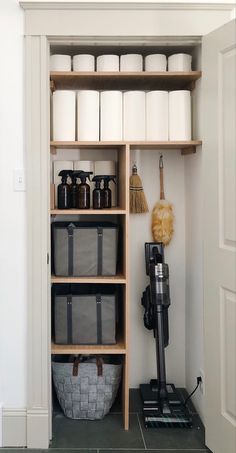 the shelves in this bathroom are filled with toiletries and cleaning supplies, along with two brooms