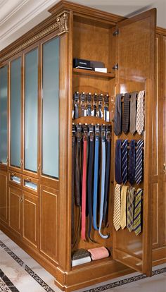 a closet filled with lots of ties next to a tiled floor in a room full of wooden cabinets