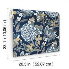 a blue and yellow flowered wall hanging on a white wall next to a ruler