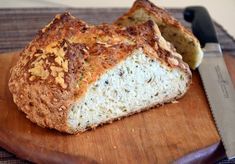 a loaf of bread sitting on top of a wooden cutting board next to a knife