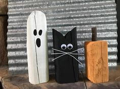 three wooden halloween decorations sitting on top of a mantle