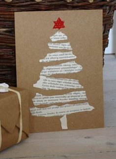 a brown card with a christmas tree on it next to a wrapped present box and wicker basket