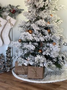 a white christmas tree with presents under it