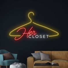 a neon sign that says her closet hangs on the wall next to a couch and chair