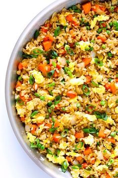 a bowl filled with rice and vegetables on top of a table