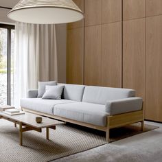 a living room with a couch, coffee table and large window