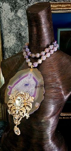 This showstopper agate and rhinestone pendant measures an impressive 8.5" x 5.25" and is surprisingly lightweight. The luxury agate slice is from Brazil and features the colors of white and purple surrounded by a translucent light brown. The very ornate art deco rhinestone or diamante pendant features aurora borealis crystals set in a gold tone alloy. The pendant is suspended from a double strand of frosted purple or lavender druzy agates, silver rhinestone rondelles, freshwater pearls and purpl Luxury Purple Agate Jewelry, Rocker Chic Accessories, Black Necklace Statement, Black Tie Formal, Formal Jewelry, Unique Pendant Necklace, Statement Bib Necklace, Mermaid Necklace, Agate Slice