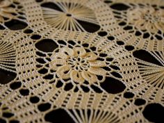 an intricate lace doily is shown on a table