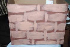 a brick wall is being painted pink with white paint on the top and bottom part